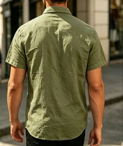Back view of a men's olive green short sleeve textured shirt in an urban street setting