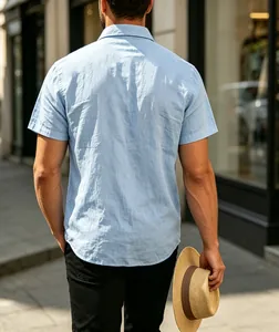 Back view of a light blue jacquard short sleeve shirt in an urban street setting.