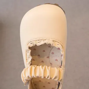 Gros plan sur chaussure princesse beige pour fille avec dentelle et motifs cœurs