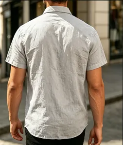 Back view of a men's light grey textured short-sleeve shirt in an outdoor setting.