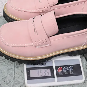 Close-up detail showing the weight of a pink frosted platform loafer on a kitchen scale