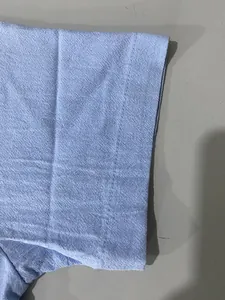 Close-up detail of light blue jacquard fabric and stitching on a men's polo shirt sleeve.