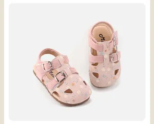 Close-up of pink floral patterns and metal buckle straps on toddler girl's sandals