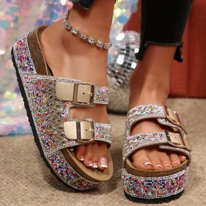 Close-up of colorful rhinestone platform sandals with double gold buckles on a model's feet.