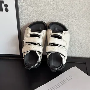 Elegante schwarz-weiße römische Sandalen für Kinder für den Sommerurlaub am Strand