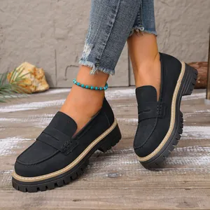 Close-up view of black vintage loafers with thick soles and matte finish on model
