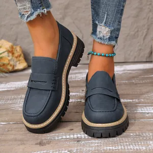 Detailed view of retro navy blue frosted loafers with chunky lug soles on model's feet