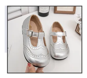 Close-up detail of silver girls' Mary Jane shoes featuring perforated wingtip design