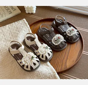 Detailed view of children's floral sandals in cream and brown with lace accents.
