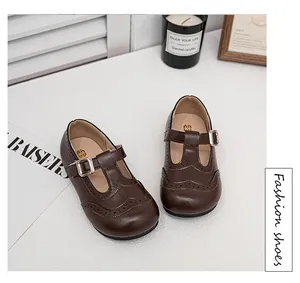 Detailed view of girls brown leather Mary Jane shoes with perforated wingtip patterns