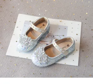 Close-up of the iridescent sequins and rhinestone flower detail on silver princess shoes