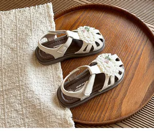 Detailed view of children's cream floral sandals with delicate lace and floral embroidery
