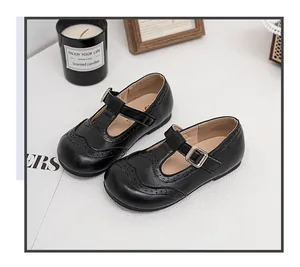 High-quality girl's black T-strap leather shoes featuring classic brogue wingtip detailing