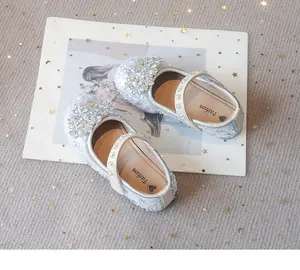 Detailed view of sparkling silver girls princess shoes with rhinestones on a decorative prop.