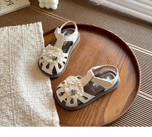 Detailed view of children's closed-toe sandals featuring sweet lace floral accents