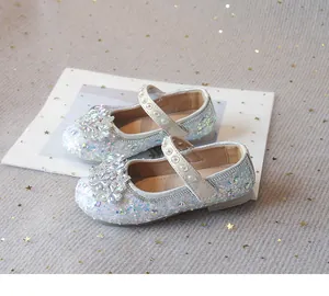 Detailed view of sparkly silver rhinestone princess shoes with floral and pearl accents