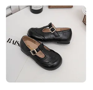 Detailed view of black girls' Mary Jane leather shoes with T-strap and brogue patterns
