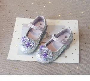 Close-up of sparkling rhinestone flower details on purple girls' princess shoes