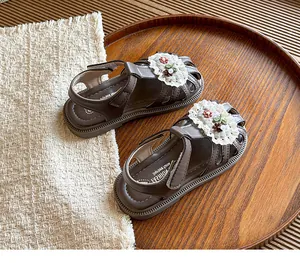 Detailed macro view of sweet brown floral lace sandals for baby girls soft sole
