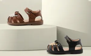 Λεπτομερής άποψη δερμάτινων σανδαλιών για κορίτσια με φιόγκο και καρό λεπτομέρειες