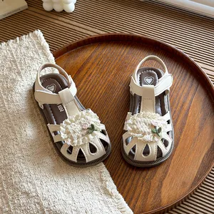 Sweet floral closed-toe children's sandals with soft soles on a wooden display