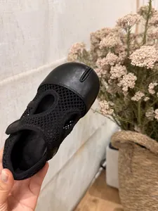 Dettaglio di scarpe Mary Jane nere in mesh per bambini con design a punta Tabi.