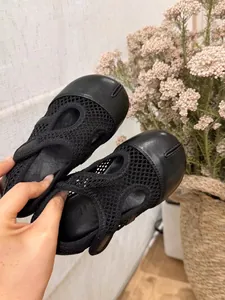Primo piano di scarpe Mary Jane nere in mesh per bambini con design unico della punta Tabi