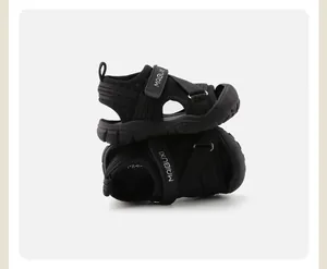 Close-up detail shot of black children's closed-toe sports sandals with soft soles.