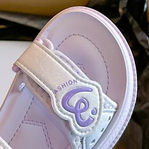 Primer plano de sandalias moradas para niñas con tira de corazón y malla transpirable