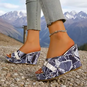 Gros plan de sandales compensées imprimé denim avec boucle blanche et motif graffiti