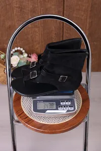 Detalle de sandalias romanas planas de ante negro con hebillas y cremallera de 343,8g