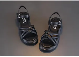 Close-up detail of black girls summer sandals with soft sole and buckle strap