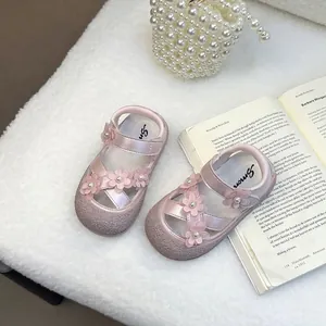 Dettaglio di sandali rosa da bambina con fiori 3D e centri di perle, stile principessa