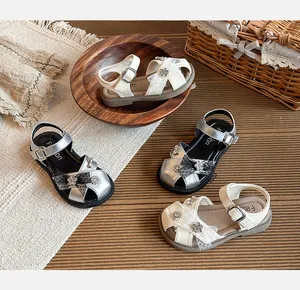 Detailed view of girls' closed-toe princess sandals in silver and cream colors