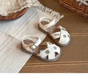 Detail of cream girls' princess sandals with hollow closed-toe and mesh flowers.