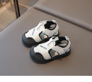 Vue détaillée de sandales fonctionnelles pour bébés en crème et noir avec attaches velcro