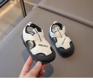 Gros plan détaillé de sandales bébé blanches et noires avec logo ABCMLX