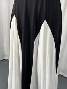 Close-up detail of an elegant black and white color-block maxi dress showing fabric folds