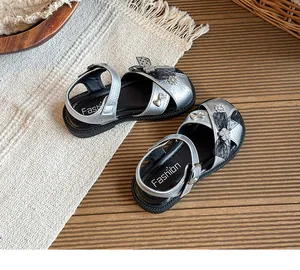 Detailed view of silver girls' princess sandals with rhinestone bows and hollow design