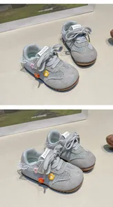 Vue détaillée de chaussures de marche grises pour bébé avec fleurs et dentelle.