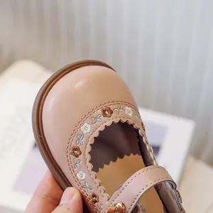 Detailed close-up of pink toddler girl Mary Jane shoes with delicate floral embroidery