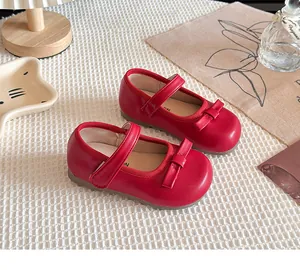 Détail de chaussures Mary Jane rouges pour petites filles avec nœud et velcro