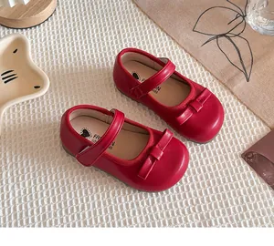 Détail des chaussures Mary Jane rouges pour enfants avec un élégant nœud décoratif
