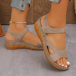 Detailed view of women's khaki wedge sandals featuring velcro straps and peep toe design