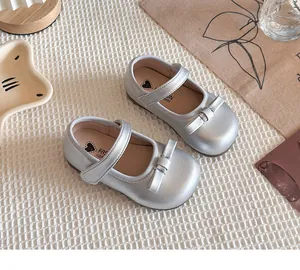 Détail de chaussures Mary Jane argentées pour filles avec nœud et bride velcro