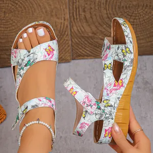 Detail of women's wedge sandals featuring colorful butterfly print and adjustable straps.
