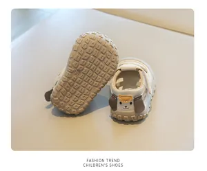 Detailed macro view of cream toddler sandals featuring a cute dog heel and non-slip sole