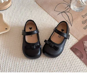 Vue de dessus de chaussures Mary Jane noires pour fille avec nœuds élégants.
