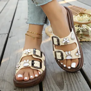 Nahaufnahme von stylischen cremefarbenen Plateau-Sandalen mit süßen Anhängern und Schnallen