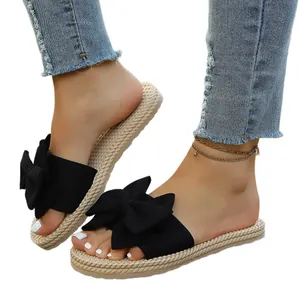 Sandali estivi bassi con grande fiocco nero e suola con texture in corda intrecciata